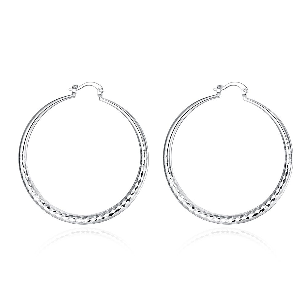 Boucles d’oreilles créoles en argent, anneau arrondi avec bord texturé en bas.