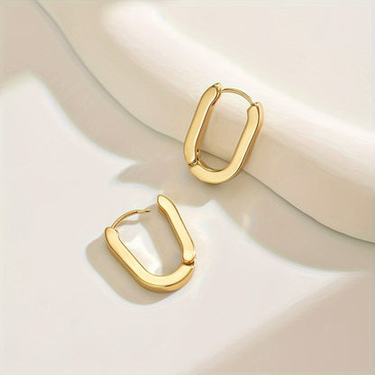 Paire de boucles créoles dorées ovales, contours géométriques, vue rapprochée