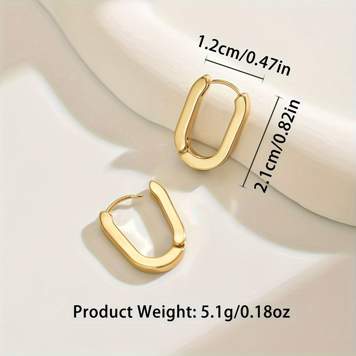 Paire de boucles créoles dorées ovales, contours géométriques, mise en évidence