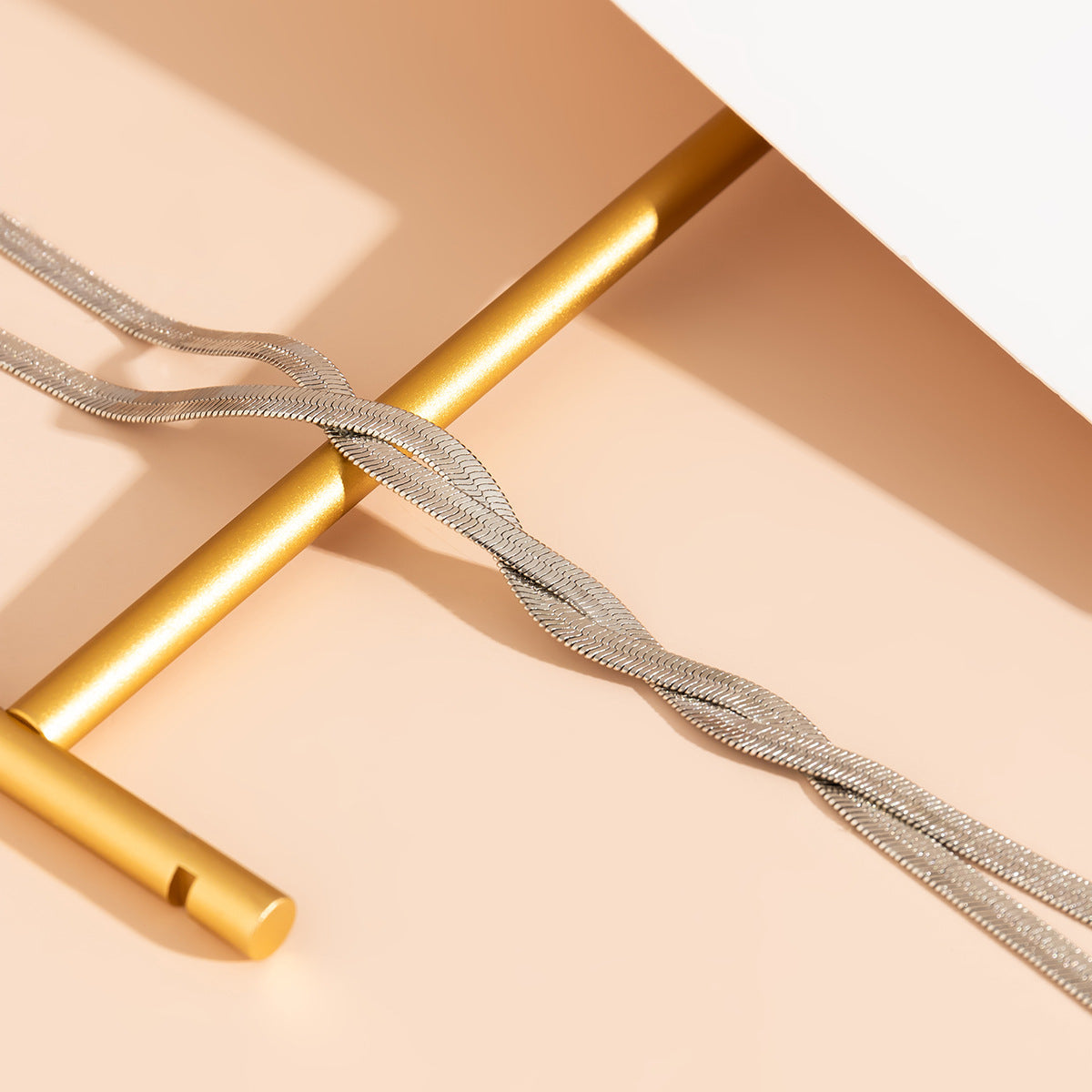 Détail du collier : chaîne torsadée argentée avec tige pendante