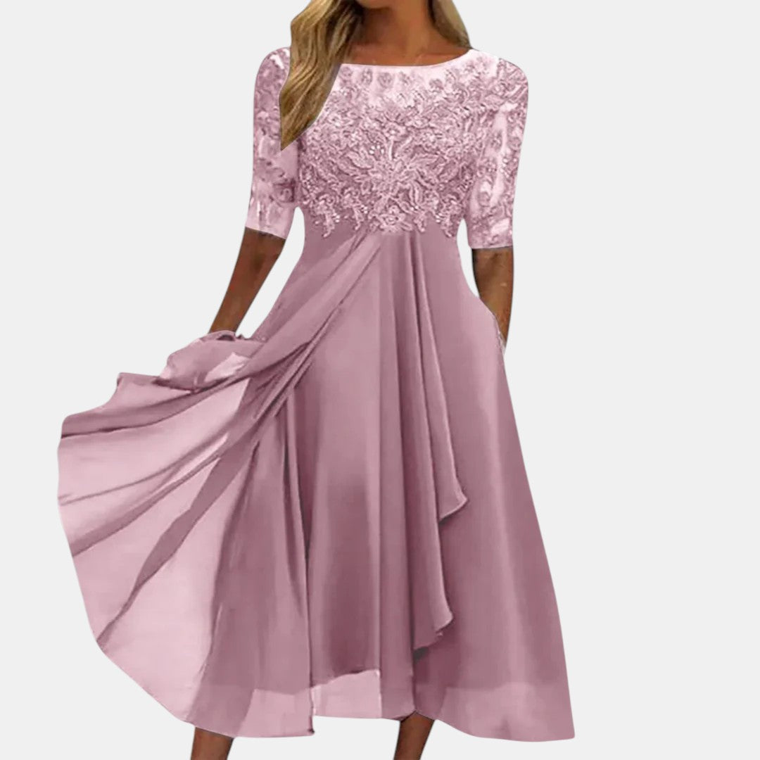 Robe en dentelle rose, encolure ronde, manches trois-quarts, jupe évasée avec drapé