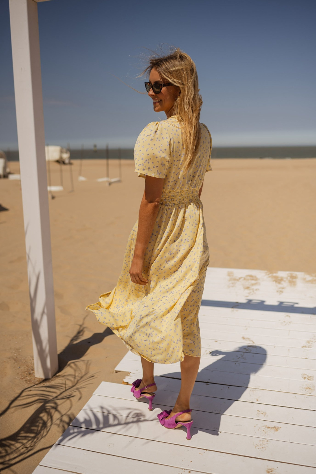 Robe midi jaune à encolure V, manches courtes, imprimé discret, fente et tenue fluide.
