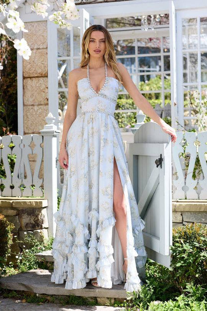 Robe longue blanche à motifs floraux, décolleté en V et volants superposés.