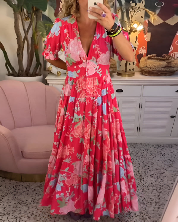 Robe longue bleue à fleurs, encolure V, manches bouffantes et jupe à volants.