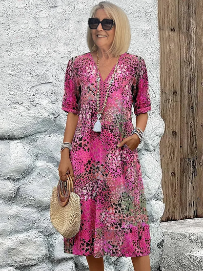 Robe midi imprimée rose poudré, col V, manches trois-quarts, détails boutonnés.