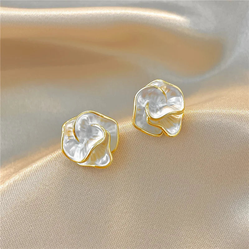 Boucles d’oreilles fleurs en perles blanches, monture dorée, détail au premier plan
