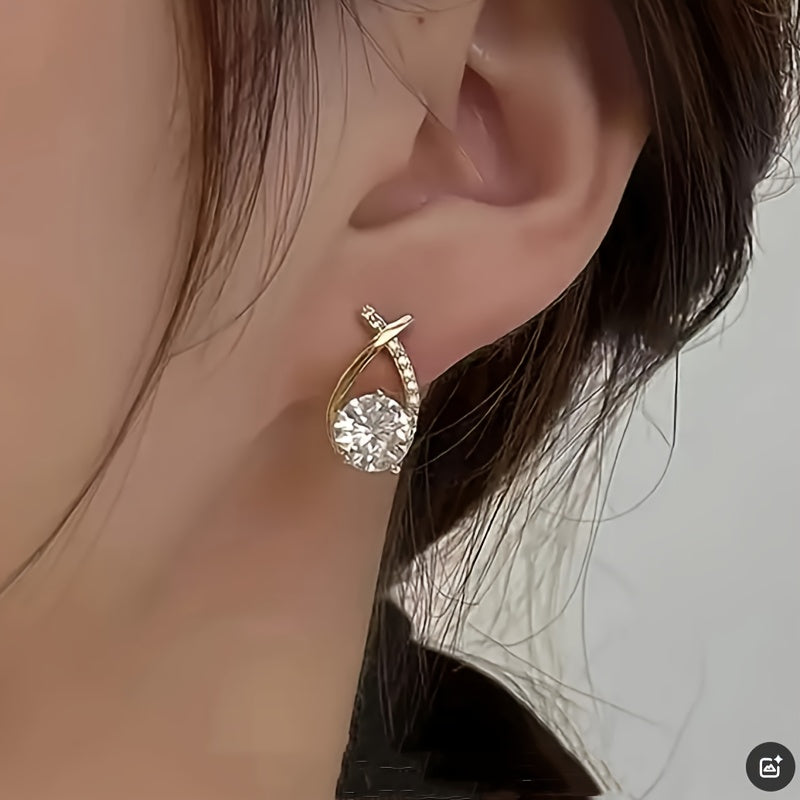 Puces d’oreilles croix dorée avec zirconium transparent, portées de profil