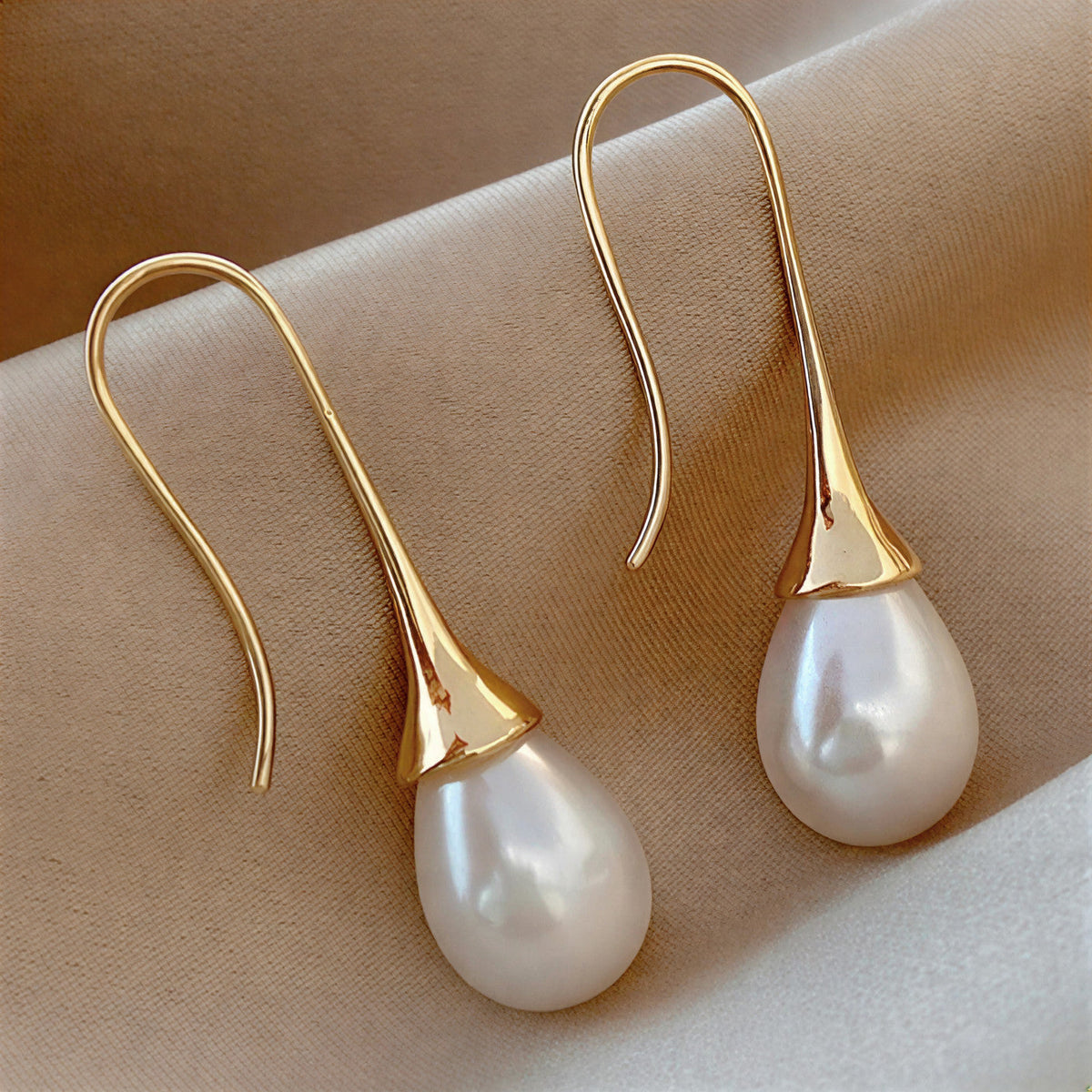 Paire de boucles d’oreilles pendantes dorées avec perle goutte blanche