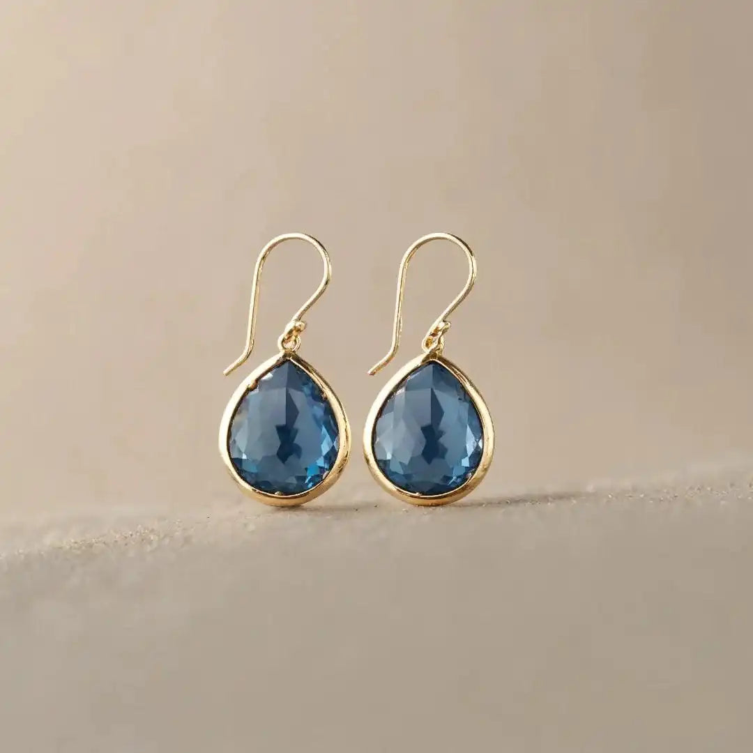 Paire de boucles d’oreilles goutte en cristal bleu, monture dorée