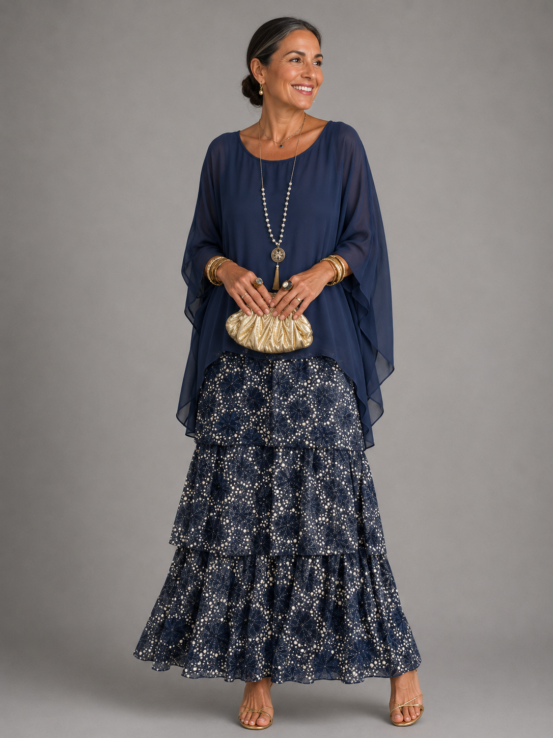 Robe longue fluide bleu marine, base à volants et motifs, manches chauve-souris, col rond.