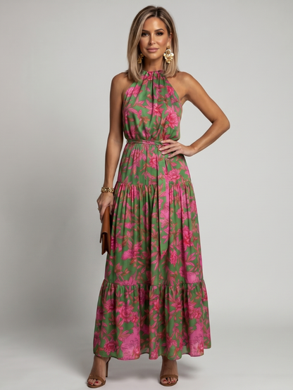 Robe mi-longue drapée à col montant, sans manches, fleurs roses sur vert, ceinture et ourlet volants.