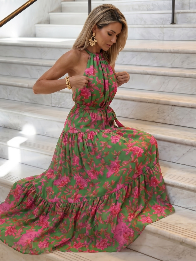 Robe mi-longue drapée à col montant, motif floral rose sur fond vert, jupe ample à volants.