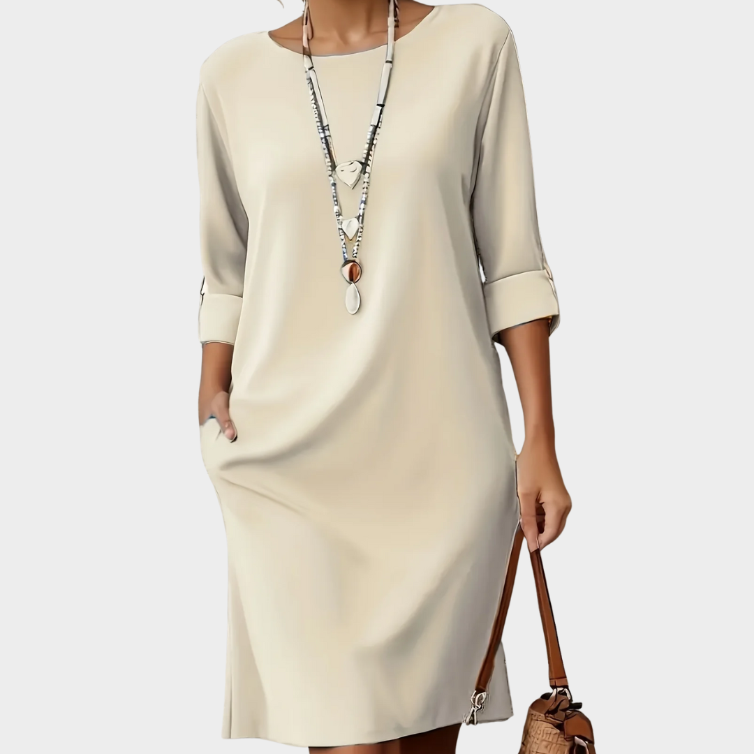 Robe mi-longue beige clair, manches 3/4, encolure ronde, coupe droite.