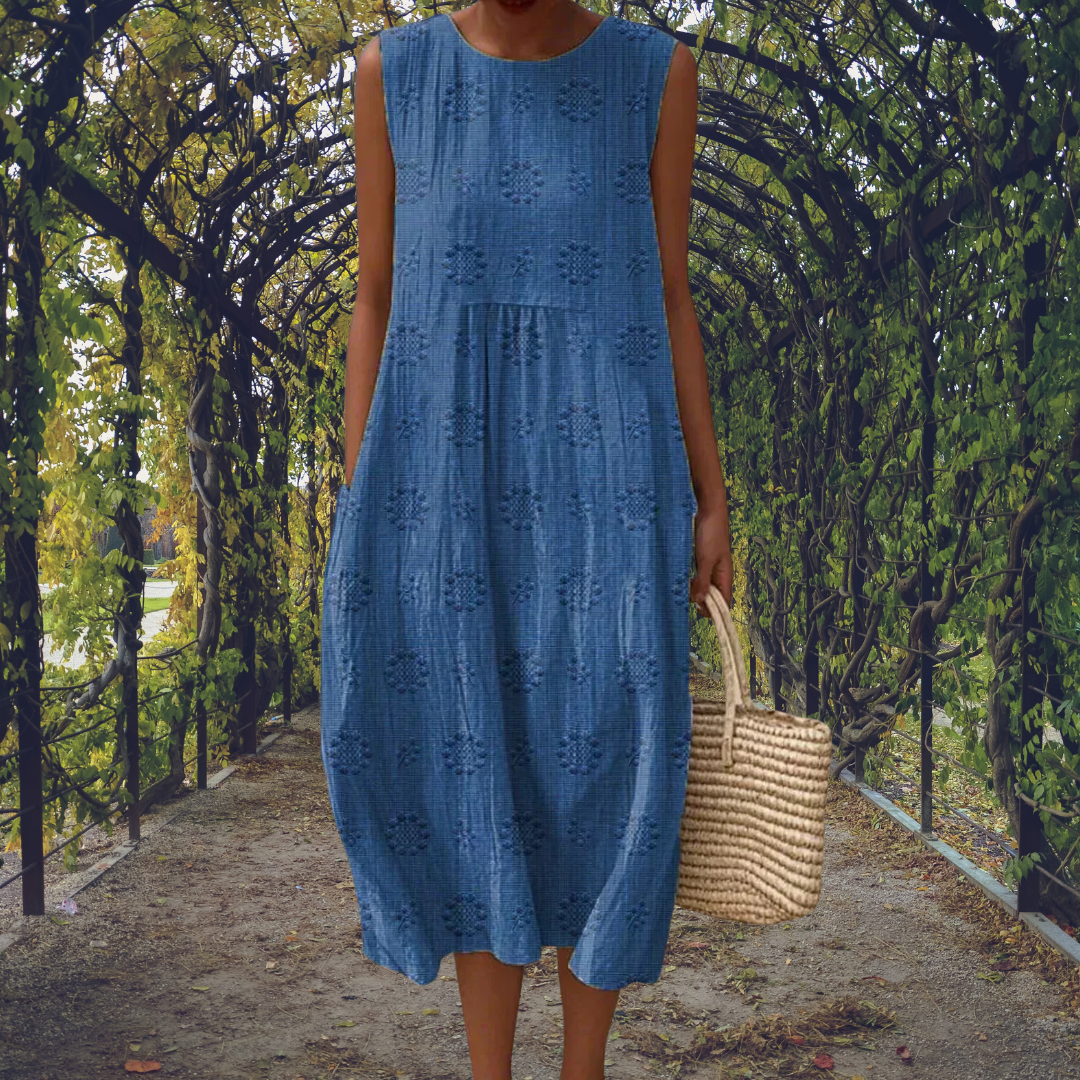 Robe sans manches bleue à broderies ajourées, encolure ronde et jupe à volants.