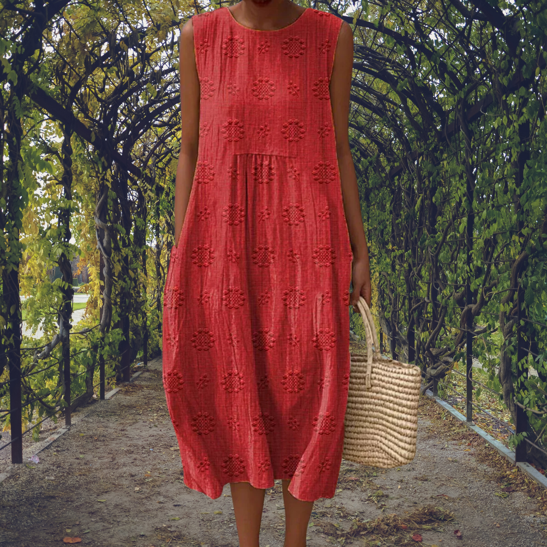 Robe sans manches rouge à broderies ton sur ton, taille smockée et jupe mi-mollet.