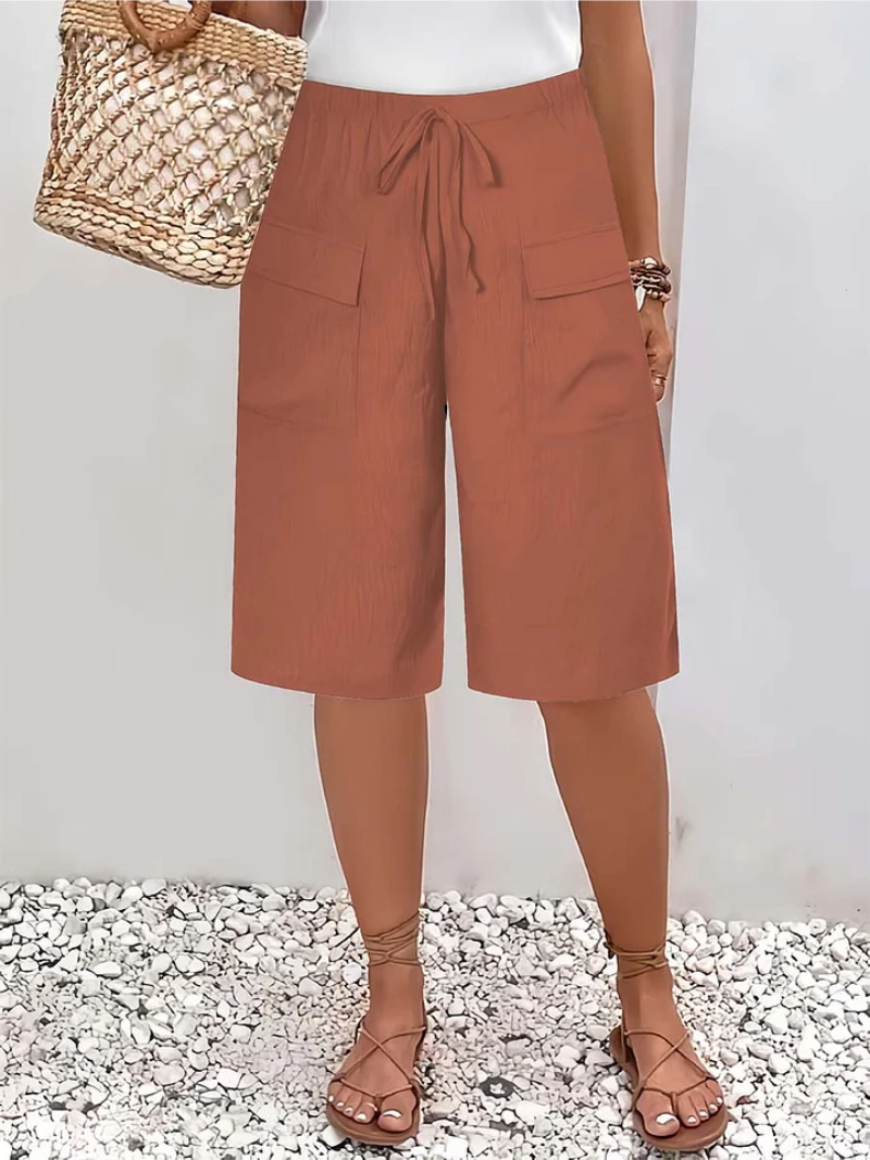 Bermuda orange à taille froncée avec cordon et poches plaquées sur les côtés.