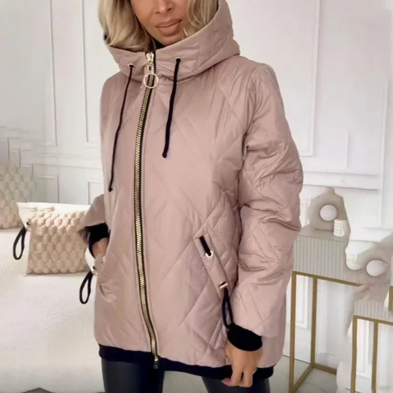 Veste matelassée rose à capuche, fermeture zippée, cordons et poches zippées.