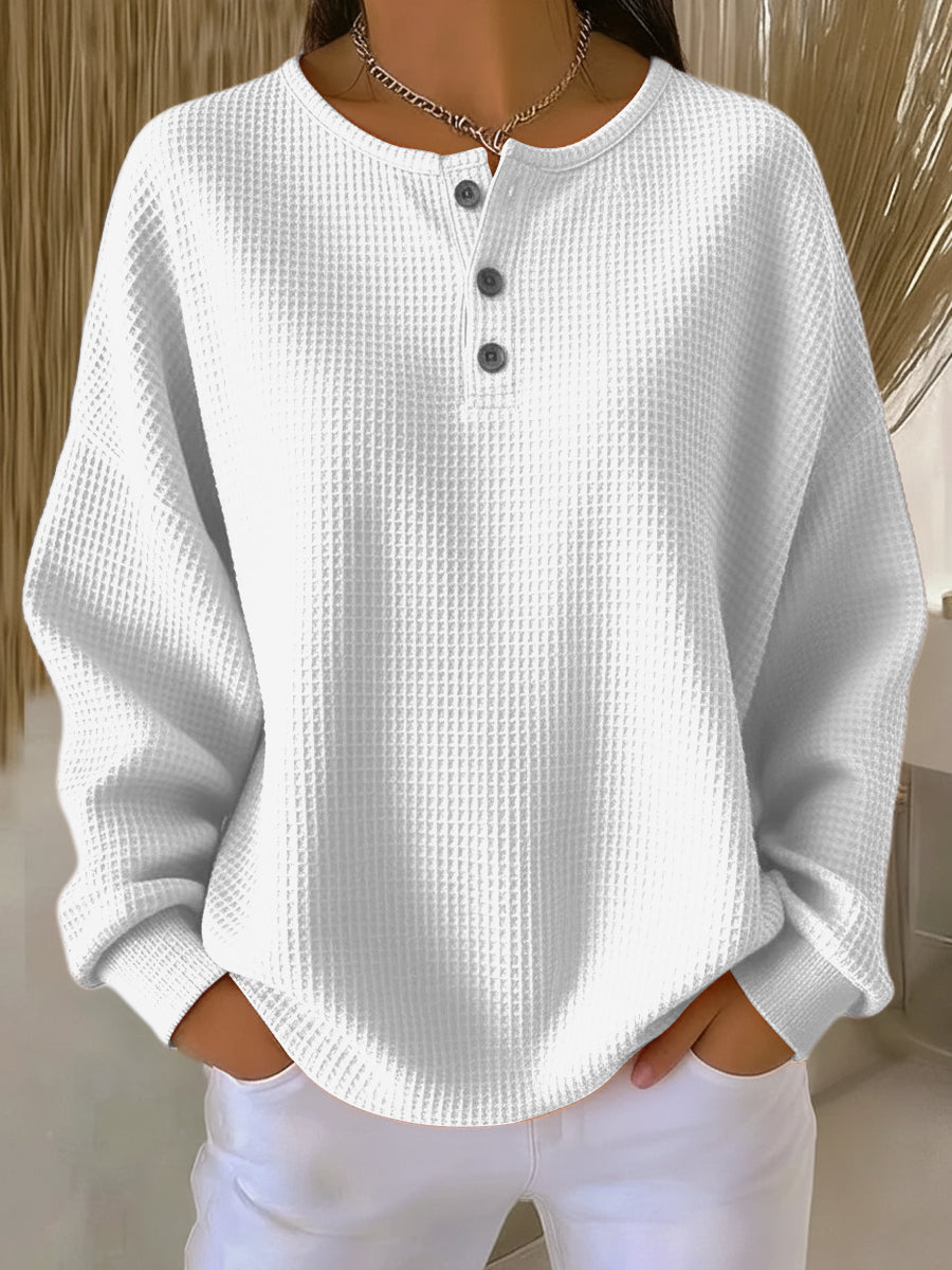Sweat-shirt boutonné blanc à encolure henley, manches longues, tissu texturé.