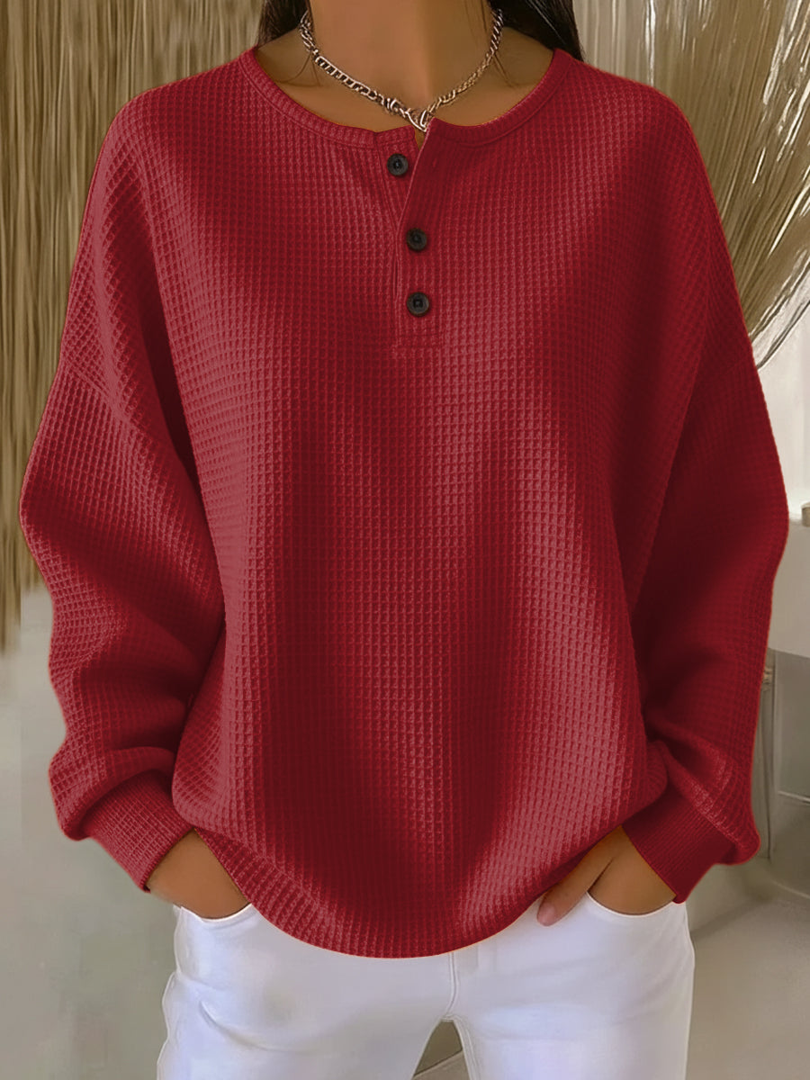 Sweat-shirt boutonné rouge à encolure henley, manches longues, tissu texturé.