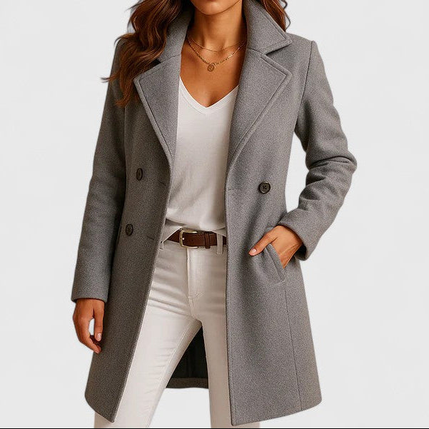 Manteau long gris à col tailleur et boutons, poches plaquées sur l’avant