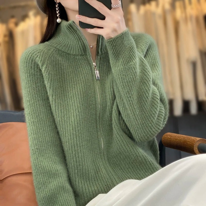 Cardigan zippé vert en maille texturée, col montant, fermeture éclair centrale visible.