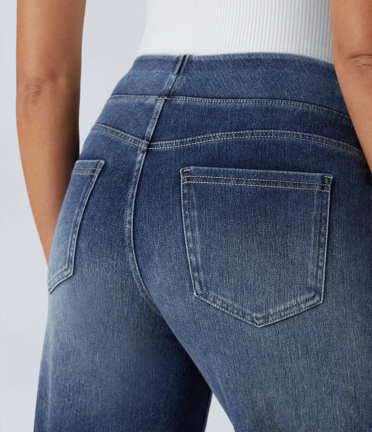 Pantalon en jean bleu avec poche arrière, surpiqûres contrastées et coutures latérales.