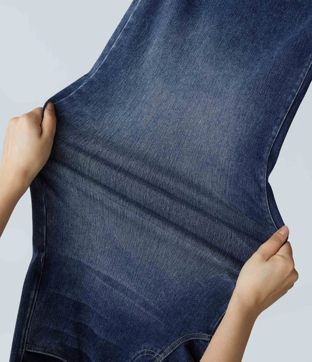 Pantalon en jean bleu, détail couture latérale et pli au niveau de la jambe.