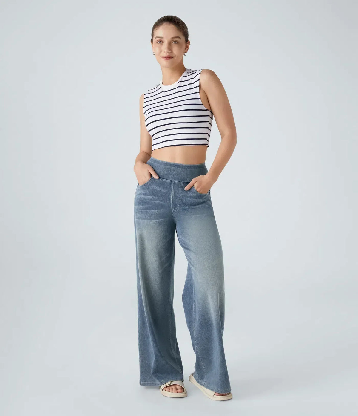 Pantalon en jean bleu clair coupe évasée, taille boutonnée, poches avant visibles.