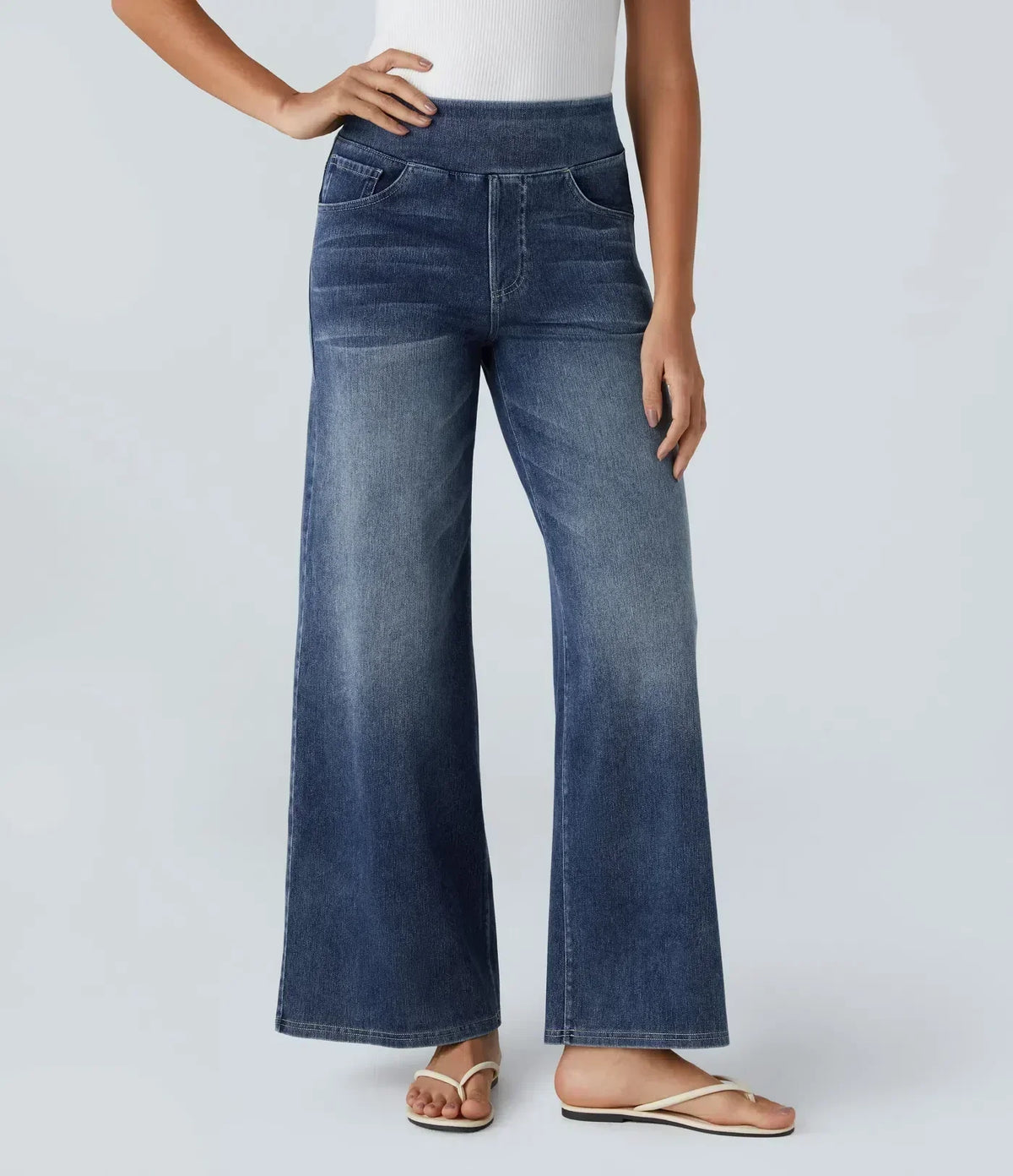 Pantalon en jean bleu, jambe évasée et taille élastique, poches avant visibles