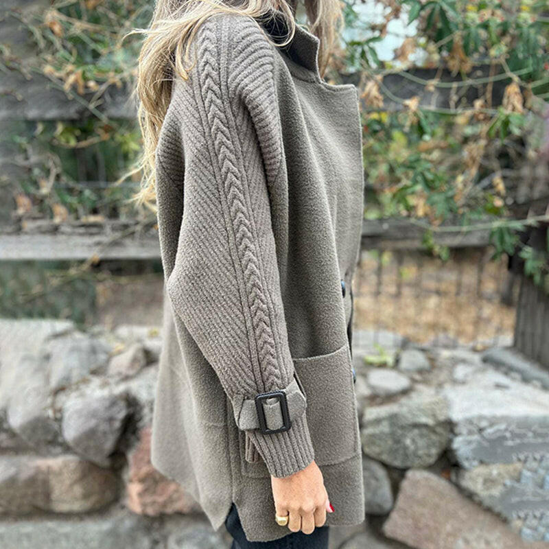Manteau mi-long gris clair, vue de profil, manches texturées et ceinture à boucle