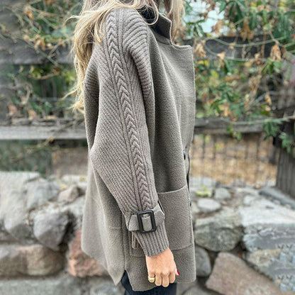 Manteau mi-long gris clair, vue de profil, manches texturées et ceinture à boucle