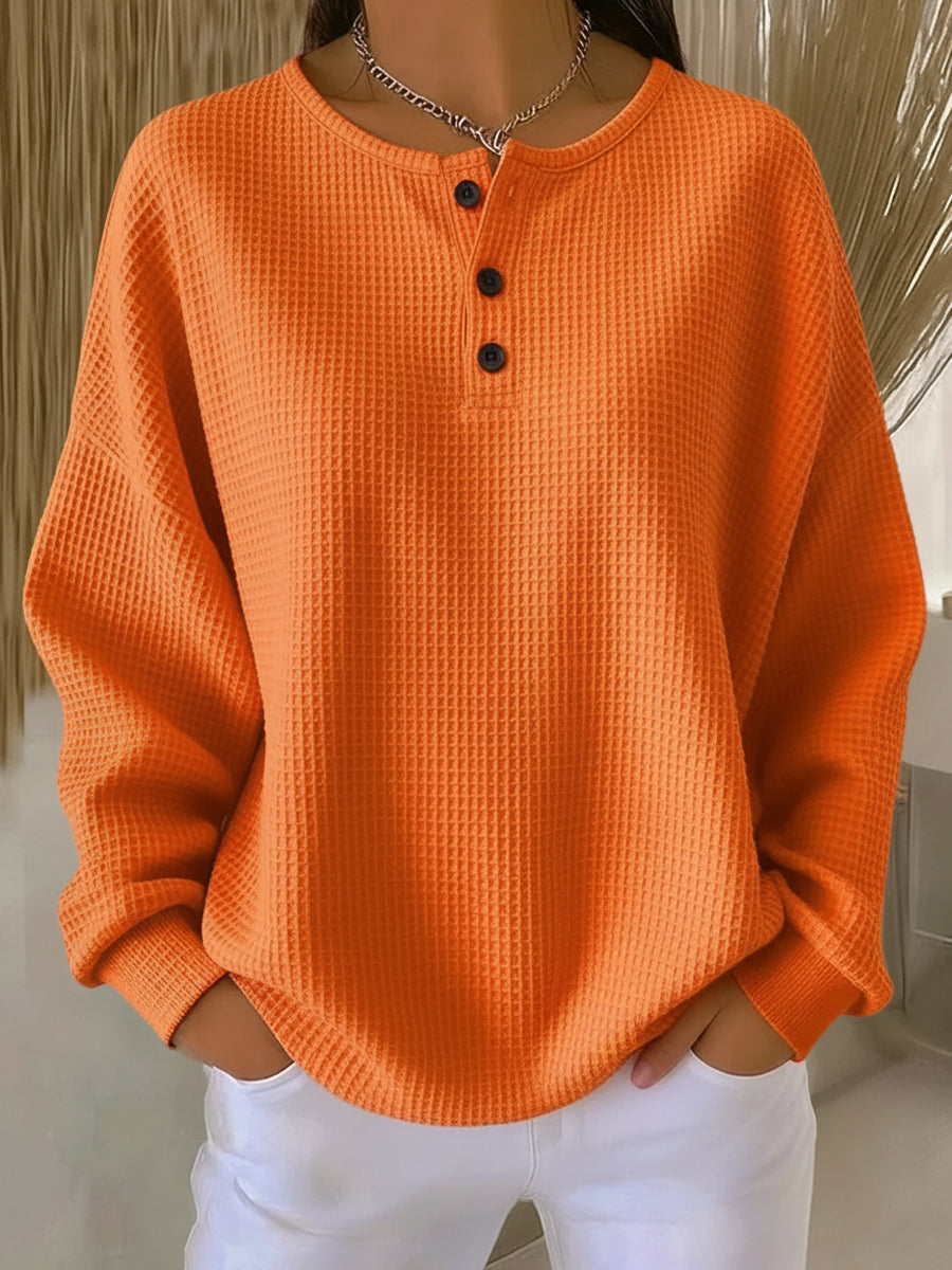 Haut manches longues orange en maille texturée, col henley boutonné à trois boutons.