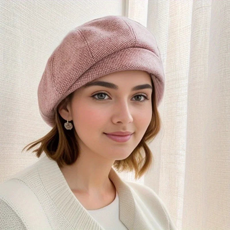 Béret rose poudré en tissu texturé, forme arrondie.