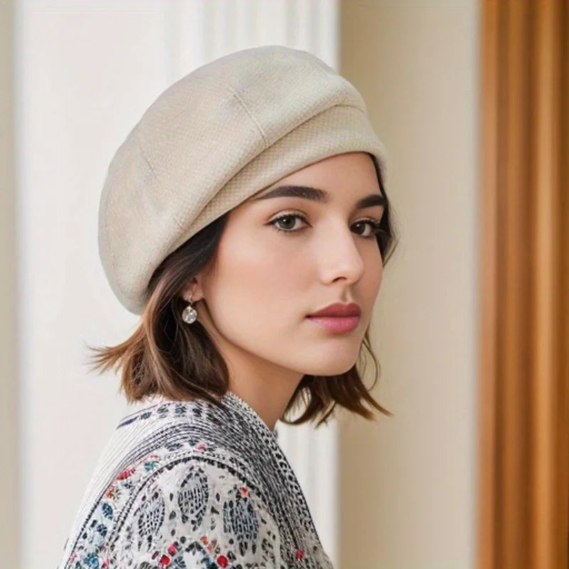 Béret beige clair en tissu texturé, porté de profil.