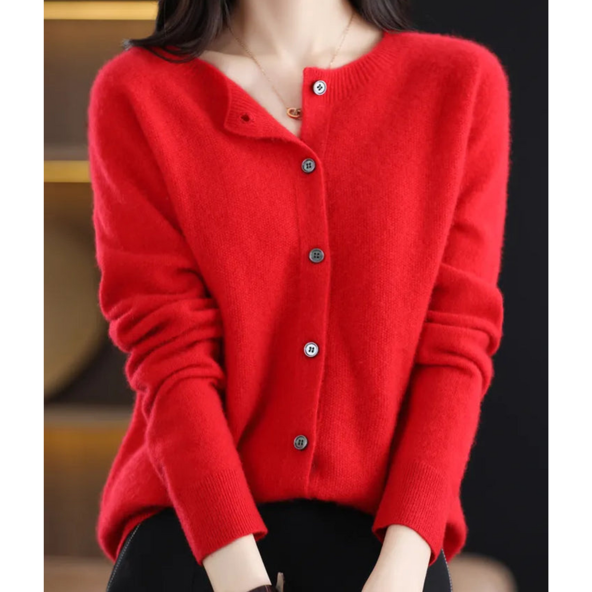 Pull en laine rouge à boutons, encolure ronde, manches longues.