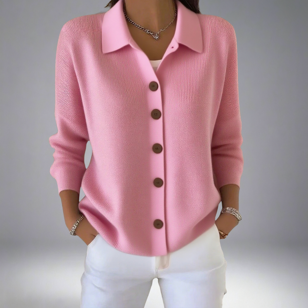 Cardigan en maille rose à boutons marron, col chemise, manches trois-quarts.