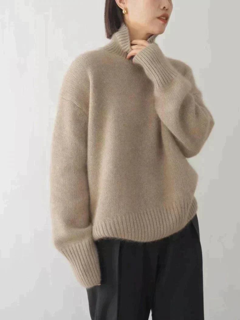 Pull en cachemire col roulé beige, coupe droite, côtes au col et aux poignets, porté devant.