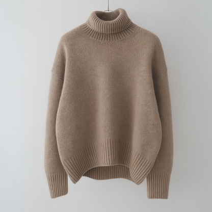 Pull oversize en cachemire taupe, col roulé côtelé, ourlet et poignets côtelés.