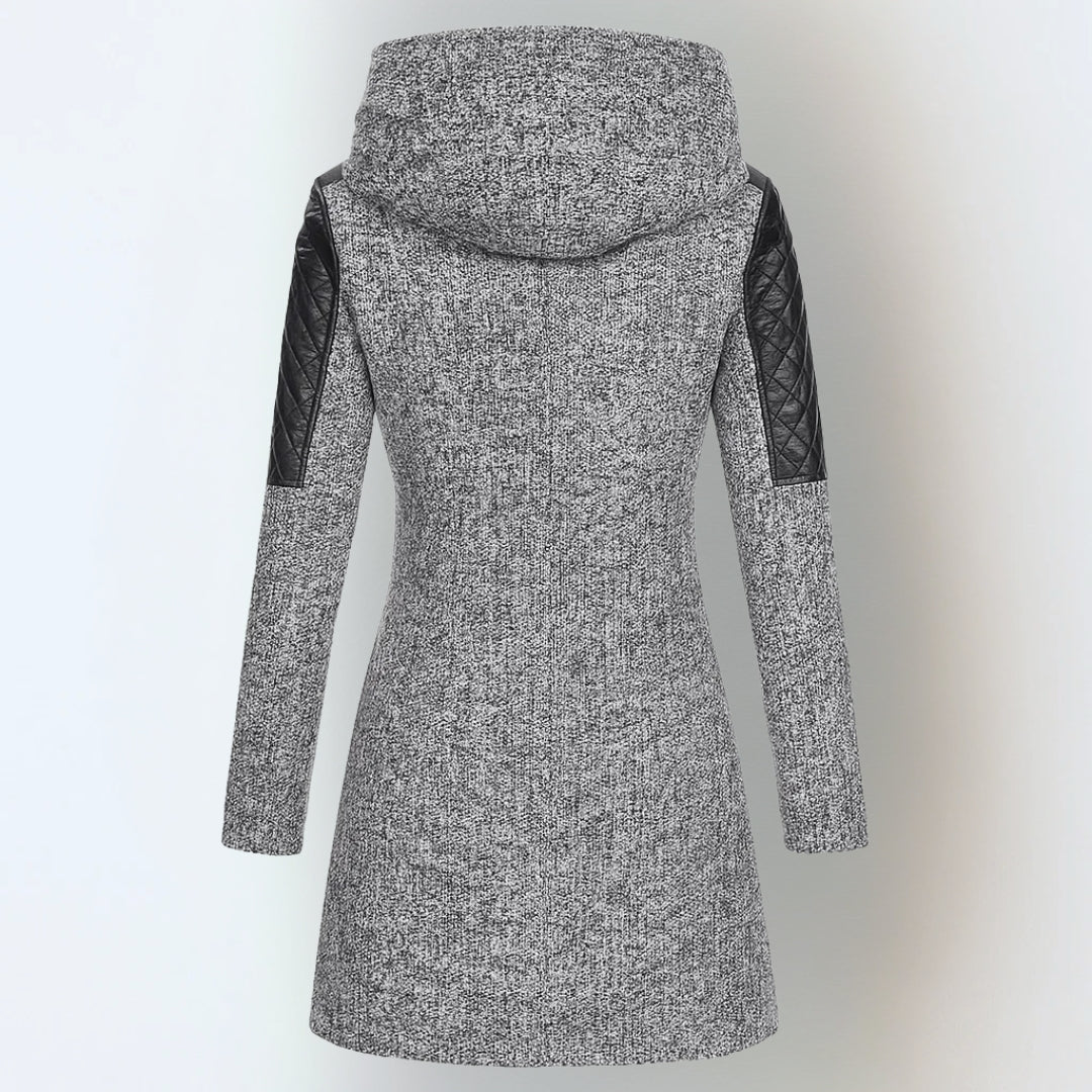 Manteau d’hiver gris chiné à capuche, manches matelassées noires, coupe longue droite.