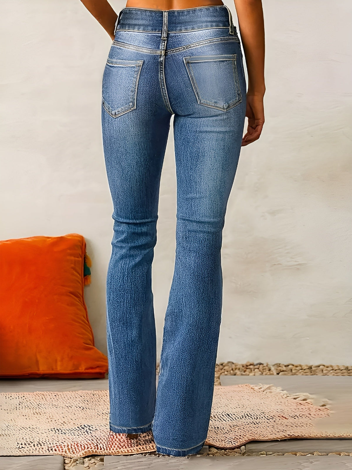 Jean évasé en denim bleu, taille mi-haute, poches et surpiqûres, bas évasé.