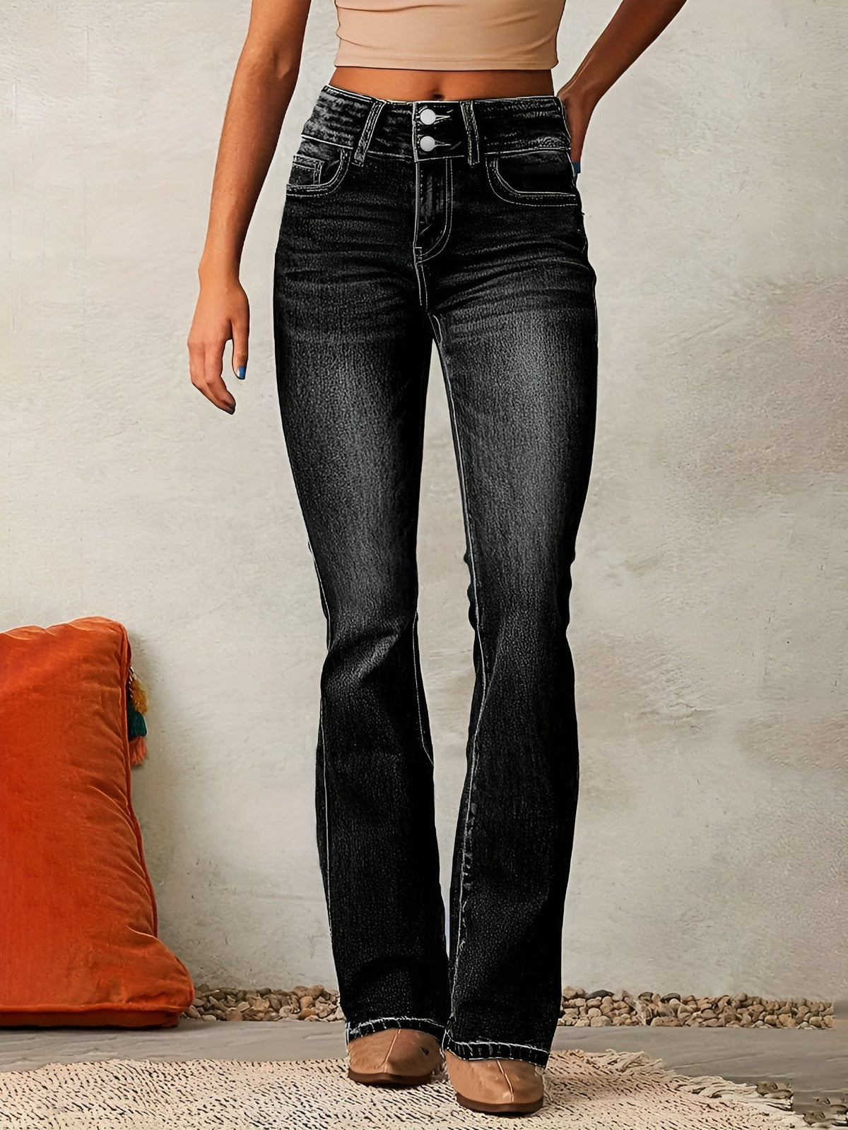 Jean évasé en denim noir, taille mi-haute, poches devant, effet délavé, bas évasé.