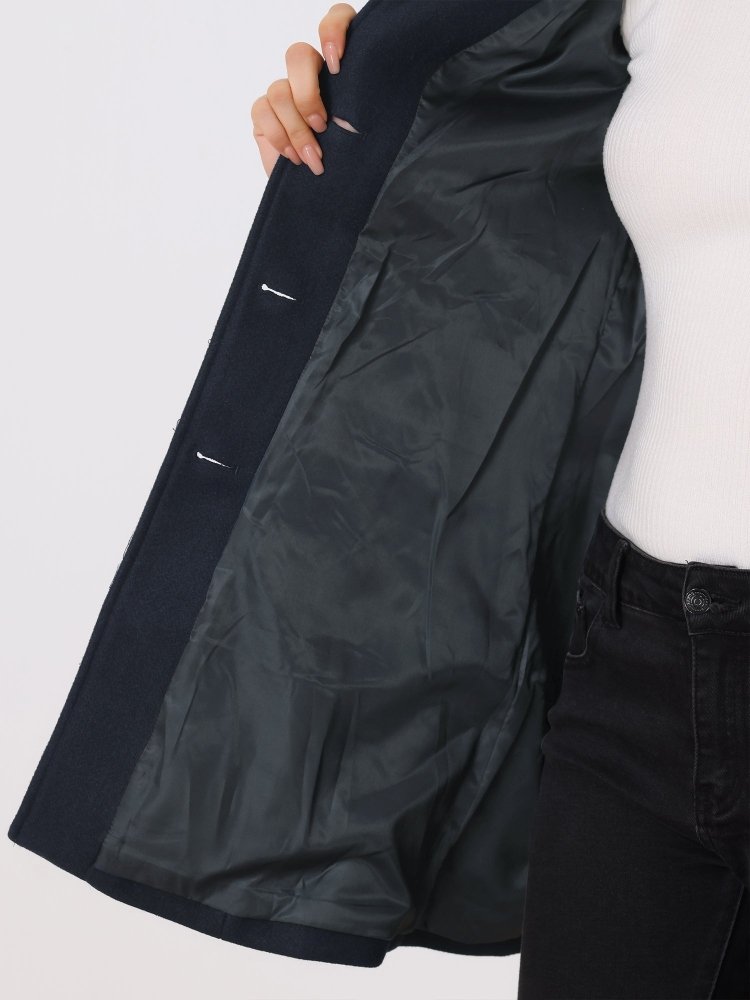 Intérieur doublé noir du manteau bleu foncé, couture et boutons-pression, gros plan.
