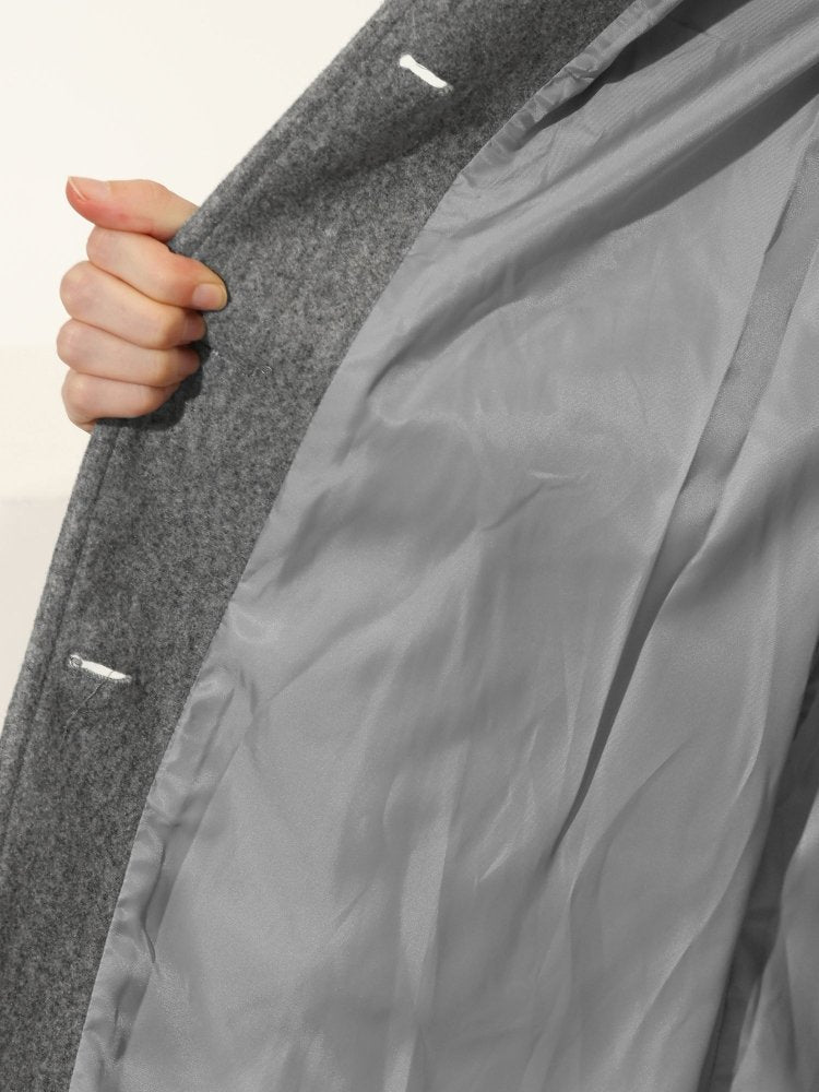 Doublure intérieure gris du manteau, tissu texturé et couture, gros plan.