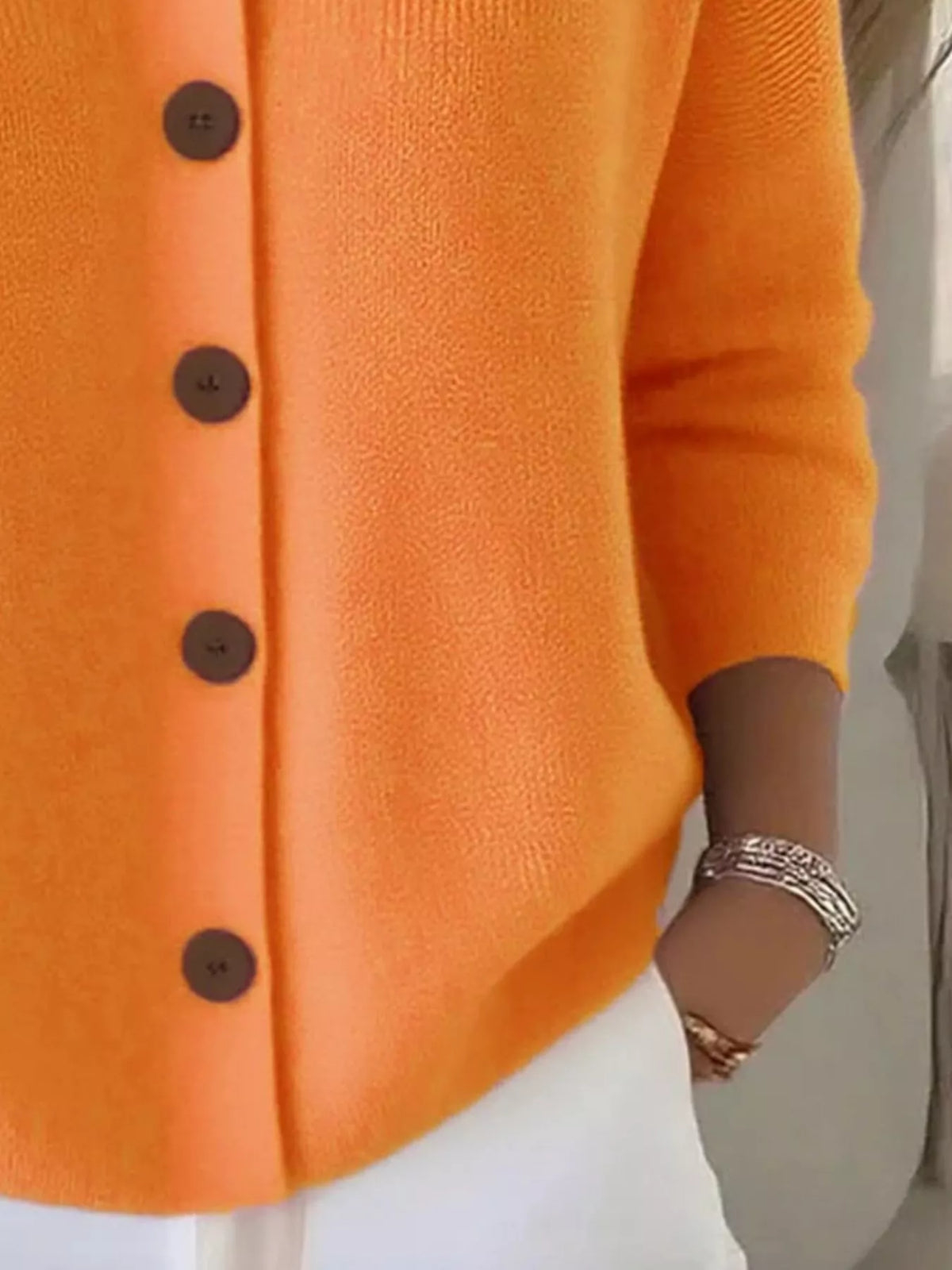 Chemisier boutonné orange, col simple, manches trois-quarts, texture tricot lisse.