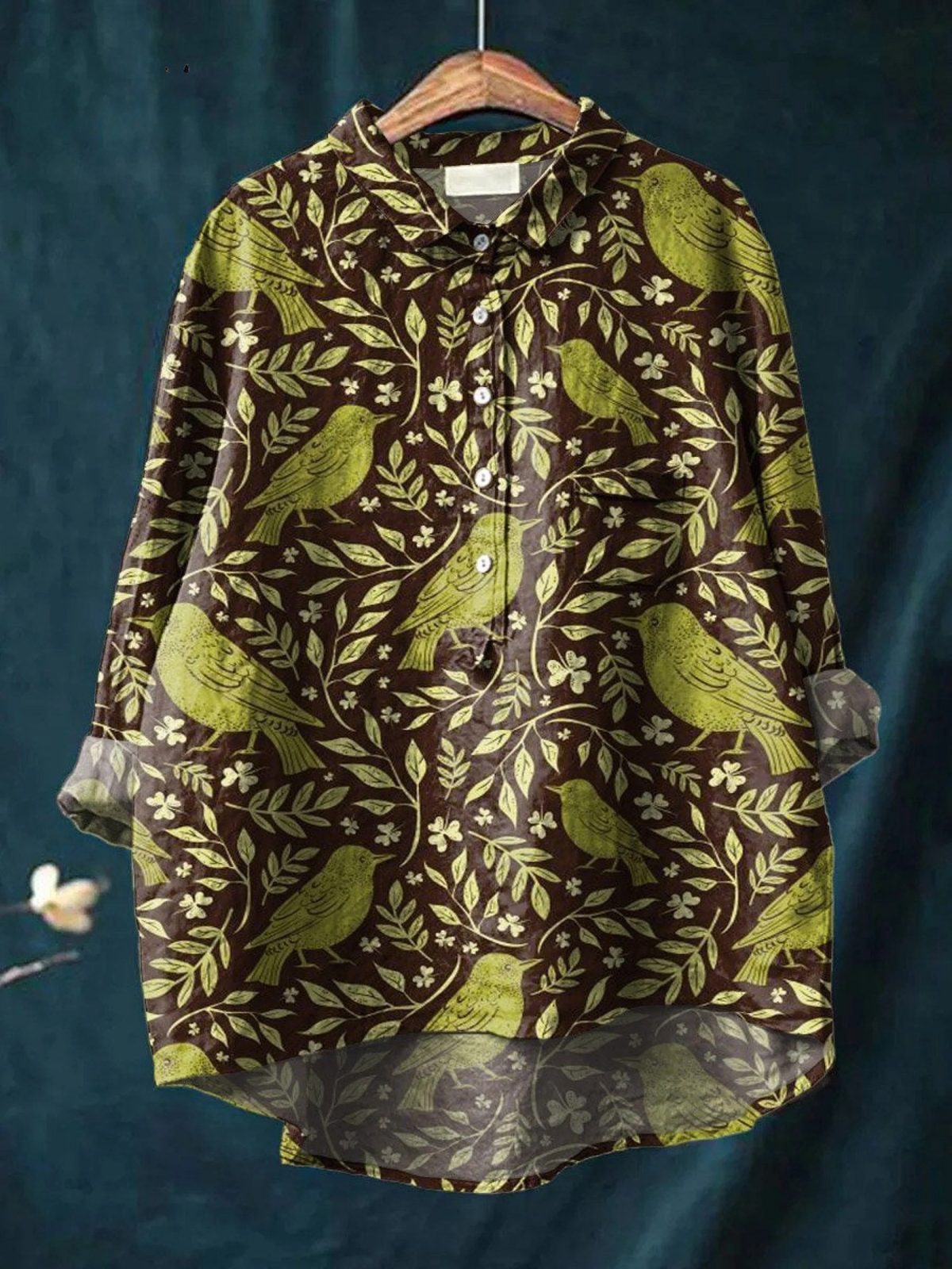 Chemise à col boutonné, motif oiseaux et feuilles vert sur fond sombre, manches longues.
