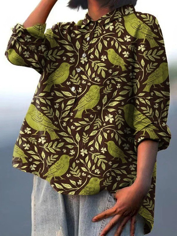 Chemise ample à manches longues, motif oiseaux et feuilles vert olive sur fond sombre.
