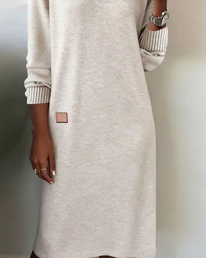 Robe tricotée gris clair, encolure V, manches longues, poignets côtelés, patche carré.