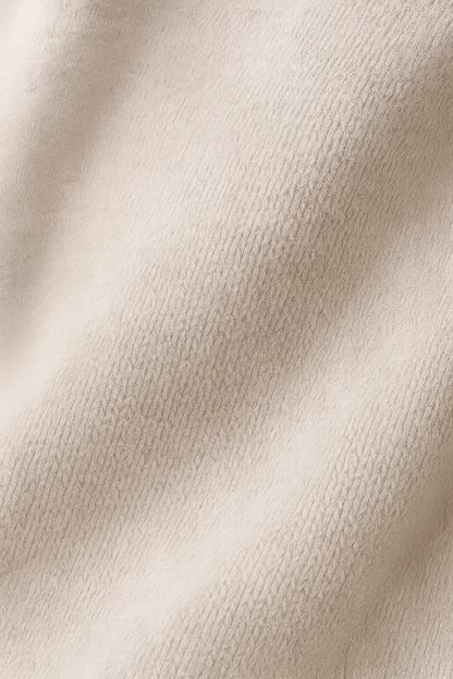Détail de maille texturée de robe tricotée beige, surface fine et tissée.