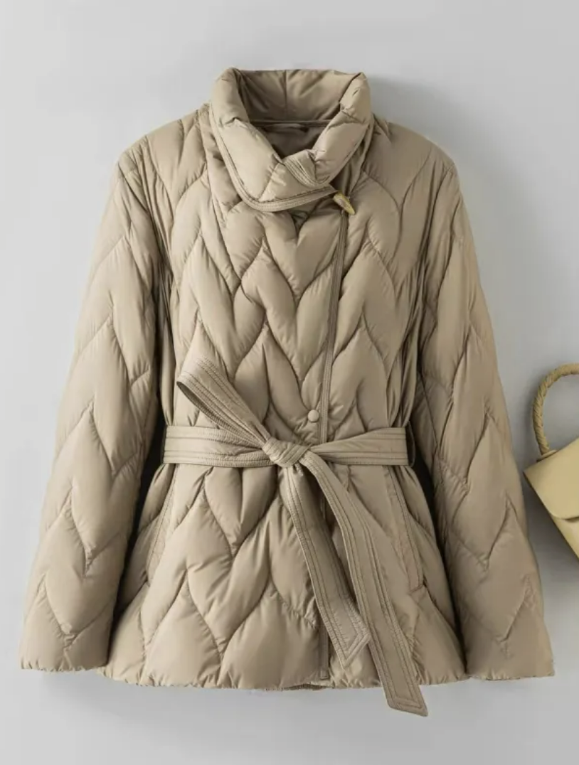 Veste d’hiver matelassée beige, col montant, ceinture à nouer, fermeture croisée.
