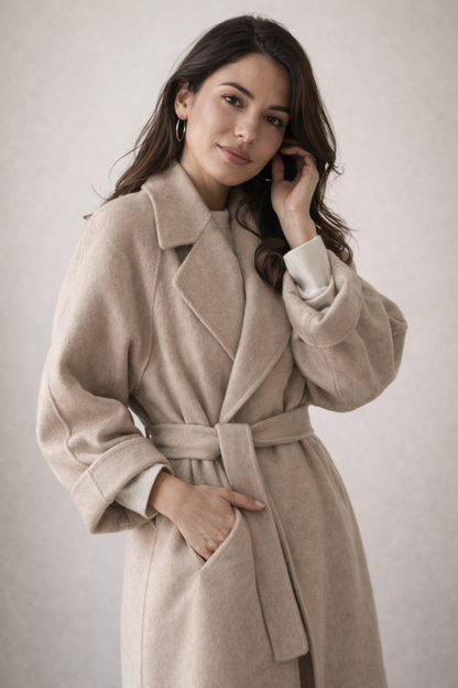 Manteau en laine beige clair à ceinture, col à revers et manches longues.